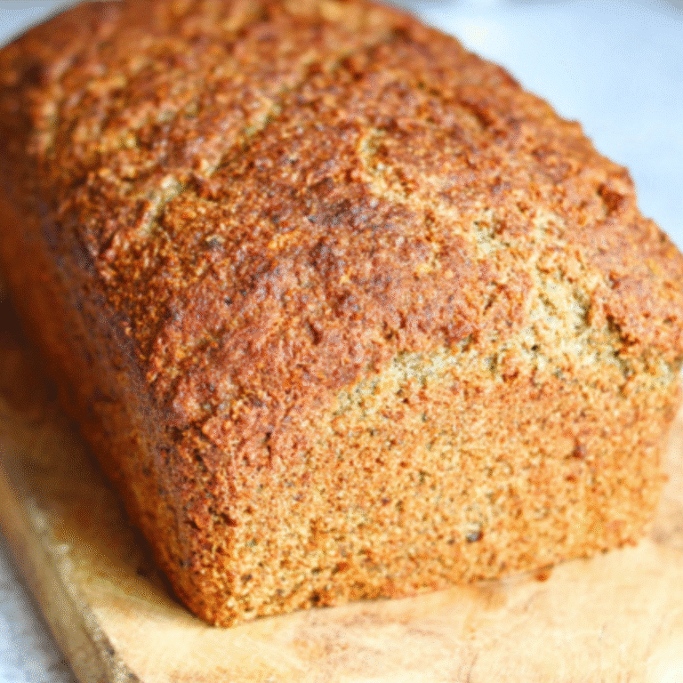 Whole loaf of keto sourdough bread on a wooden cutting board